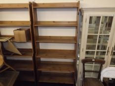 A tall set of open pine book shelves