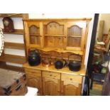 A pine kitchen dresser with glazed cupboards