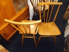 A pair of elm seated Ercol dining chairs