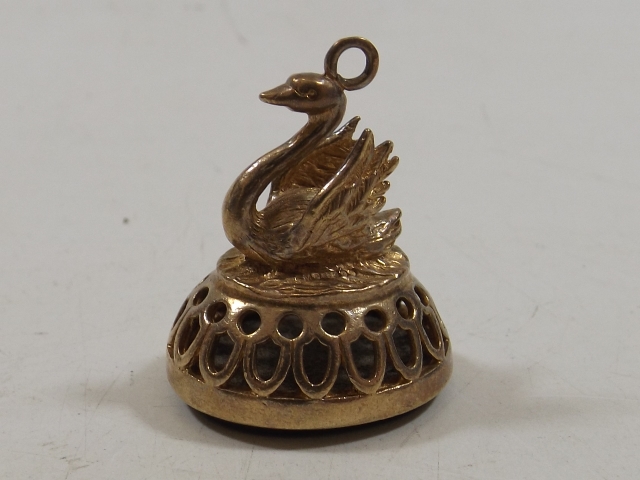 A yellow metal seal in form of swan upon nest