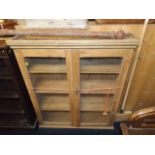 An early 20thC. stripped pine glazed bookcase