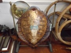 A brass mounted turtle shell with brass plaque ins