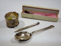 A silver napkin ring, a small silver spoon, a whit