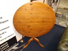 A circular pine tilt top breakfast table