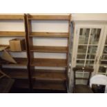 A tall set of open pine book shelves