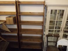 A tall set of open pine book shelves