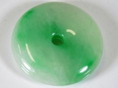 A polished Jade style disc pendant