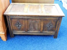 An oak blanket box with carved decor