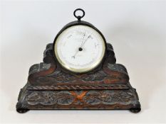 A late Victorian Negretti and Zambra brass cased barometer mounted on a decorative carved plinth