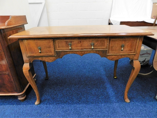 A 1920's walnut veneered low boy with three drawer