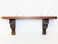 An antique mahogany shelf with gadrooned supports