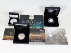 A commemorative Waterloo £5 coin & three other coi
