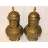 A pair of Asian brass lidded vases with detailing