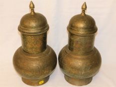 A pair of Asian brass lidded vases with detailing