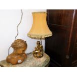 A gilded figurative lamp base with shade