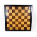 An early 20thC. chess board with lacquered frame