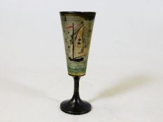 A small white metal goblet depicting yachting scen