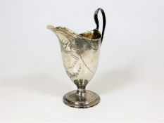 A Georgian helmet style silver creamer with chased