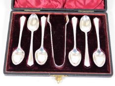 A boxed set of six silver spoons with tongs