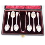 A boxed set of six silver spoons with tongs