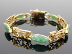 A yellow metal & jade bracelet
