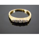 An 18ct gold ring set with five diamonds on scroll