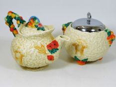 A Clarice Cliff teapot, two chips on inner rim & a similar biscuit barrel