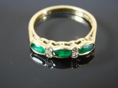 An 18ct gold ring set with emeralds & diamonds
