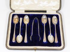 A boxed set of six silver spoons with tongs