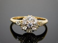 An early 20thC 18ct gold daisy style ring set with diamonds