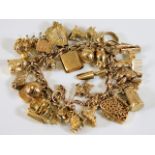 A 9ct gold charm bracelet with approx. twenty eigh