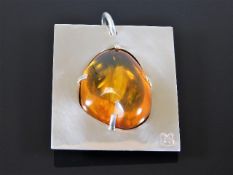 A white metal mounted amber nugget