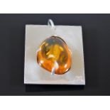 A white metal mounted amber nugget