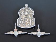 A silver ARP badge twinned with two small RAF badg
