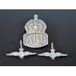 A silver ARP badge twinned with two small RAF badg