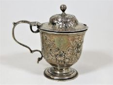 A 19thC. silver mustard with chased decor