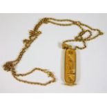 A yellow metal chain with Egyptian style pendant