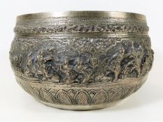 A large white metal Indian bowl with embossed figu
