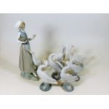 A porcelain Lladro figure with goose twinned with