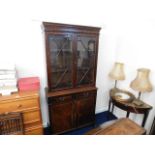 A 20thC. mahogany style lit display case with cupb