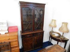 A 20thC. mahogany style lit display case with cupb