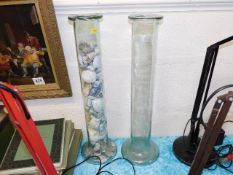 Two tall floor standing glass vases