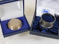 A small silver box twinned with silver napkin ring
