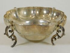A silver lobbed bowl with dragon feet