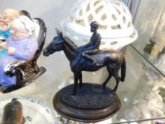 A bronze figure of jockey on horse mounted on marb