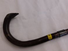 A traditional hook handled walking cane with silve