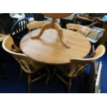 A circular pine table with four chairs