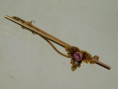 An antique yellow metal bar brooch with a 15ct flo