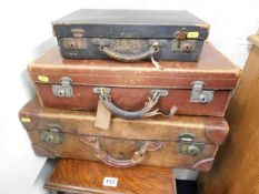 A leather tan suitcase & two others