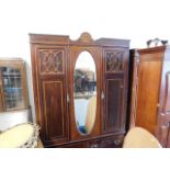 An Edwardian double wardrobe with centre oval mirr